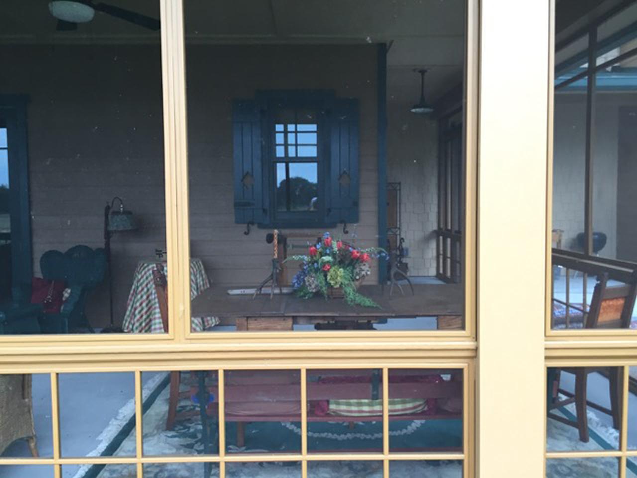 View through screen porch of board and batten operable shutters