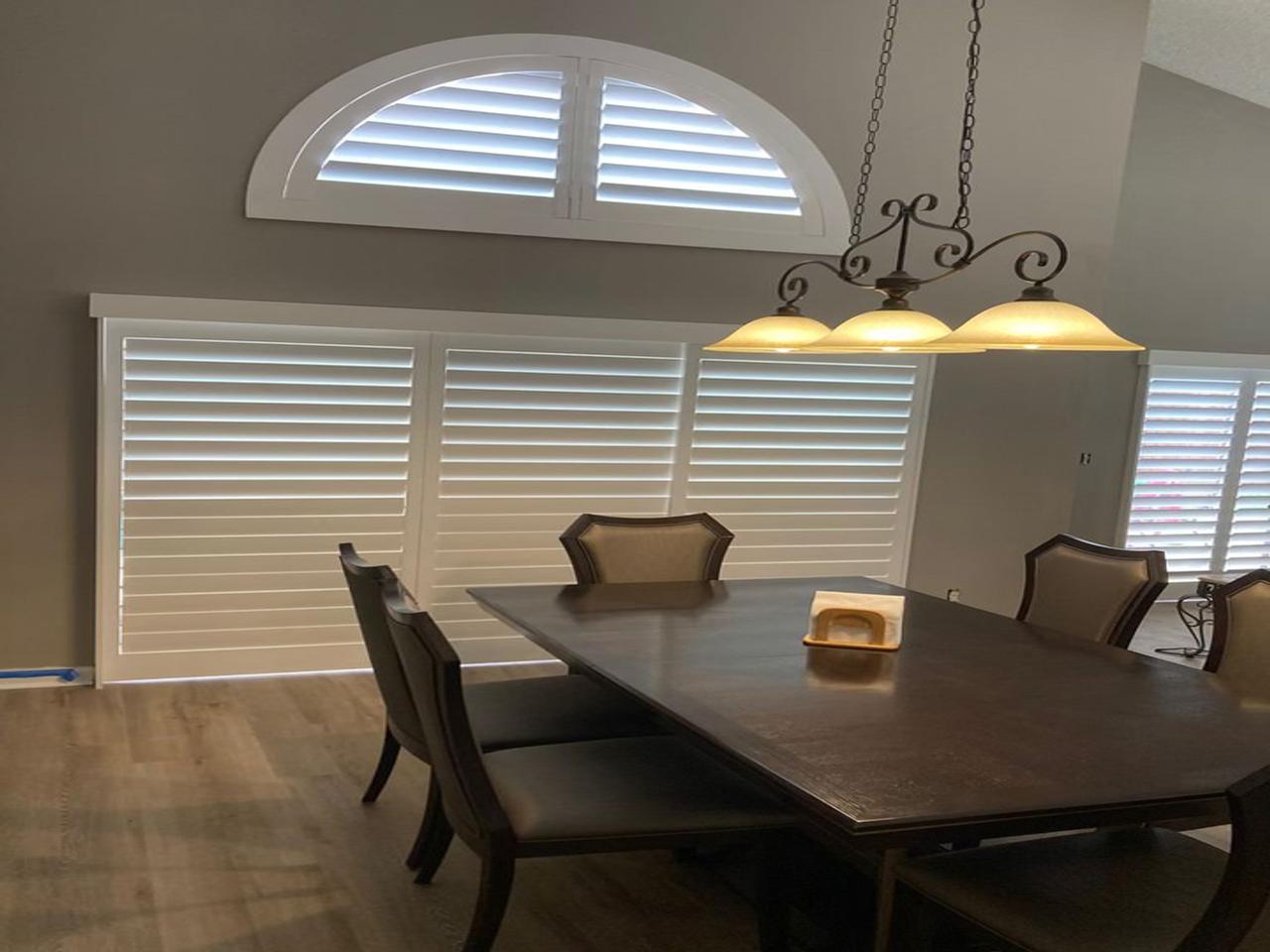 Dining room with arch and shutters on sliding glass doors