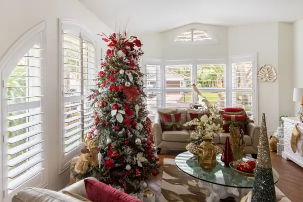 Christmas tree in living room with shutters on the windows