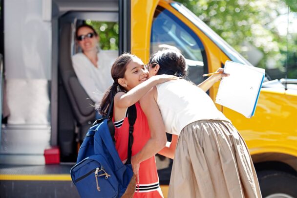 child getting on school bus