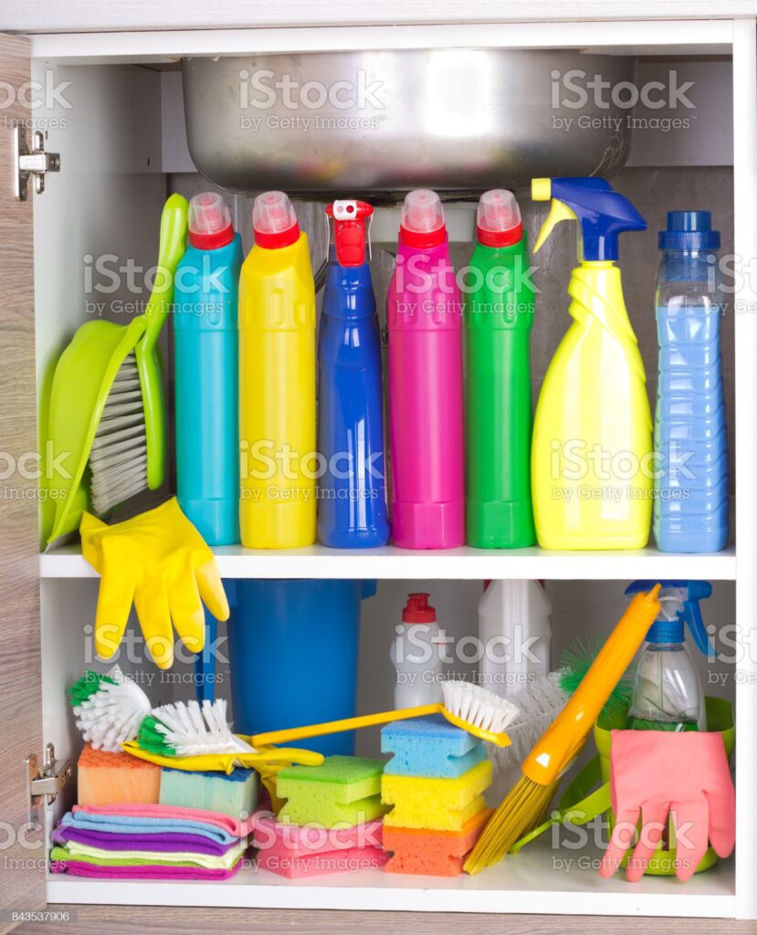 Cleaning products placed in kitchen cabinet under sink. Housekeeping storage space