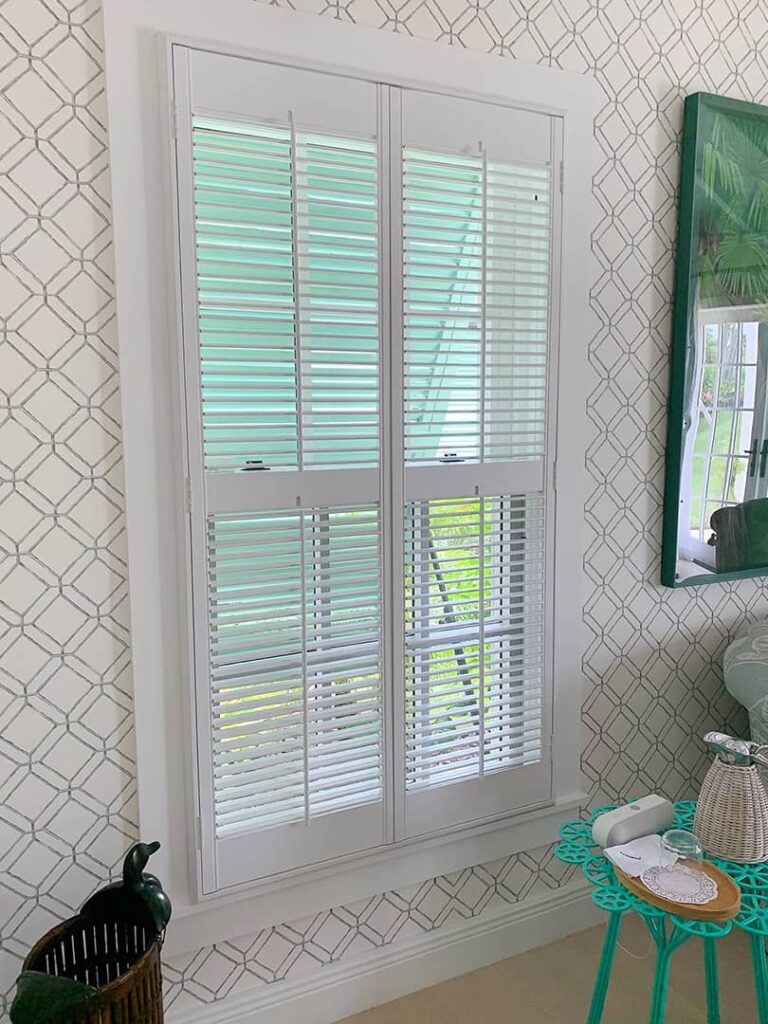 white traditional shutters on double-hung window