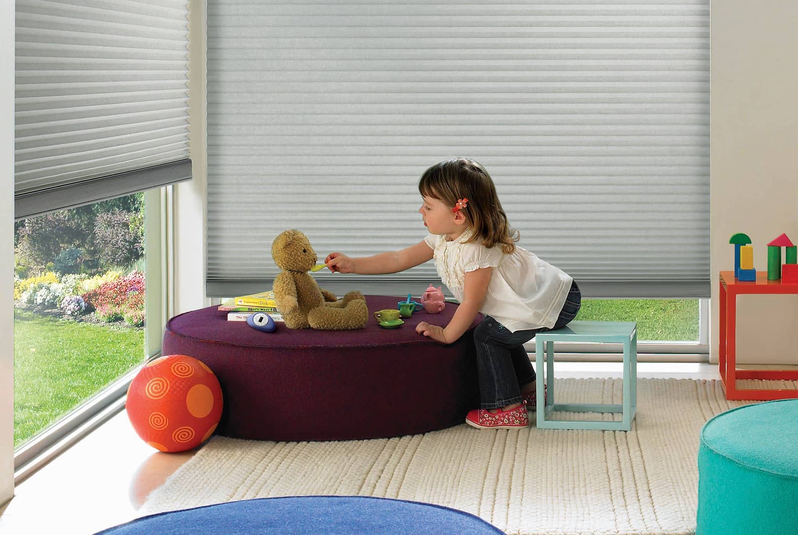 young girl playing near window covered with cordless cellular shades